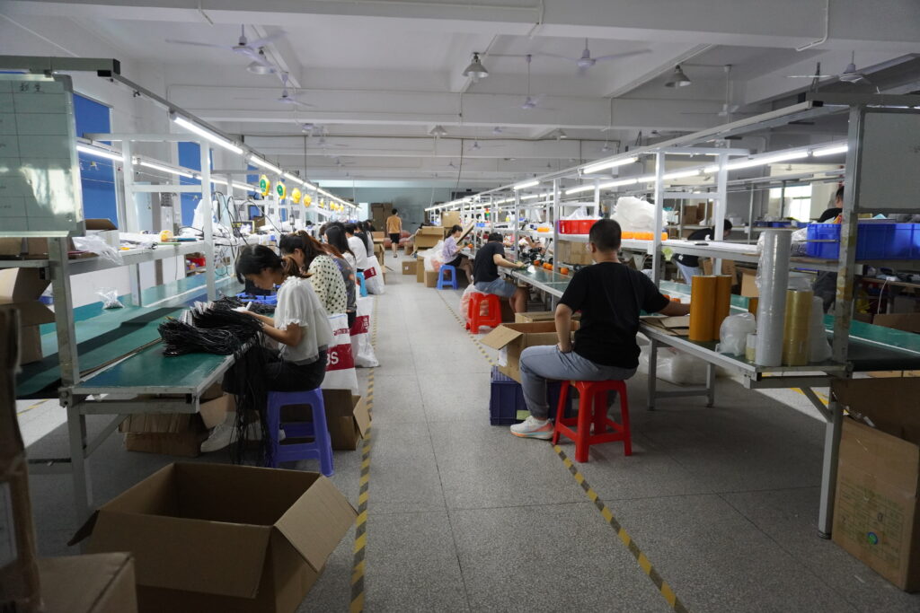LED lighting factory assembly workshop, workers assembling festival string lights, production line interior