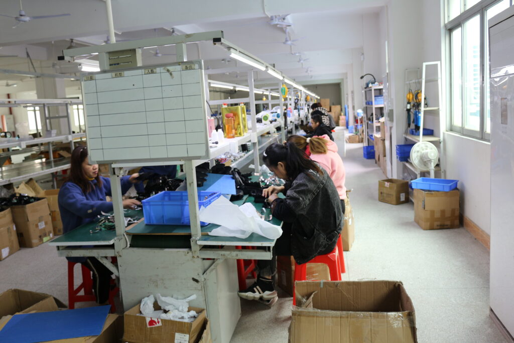 Workers assemble LED decorative lights at independent workstations beside factory workshop windows